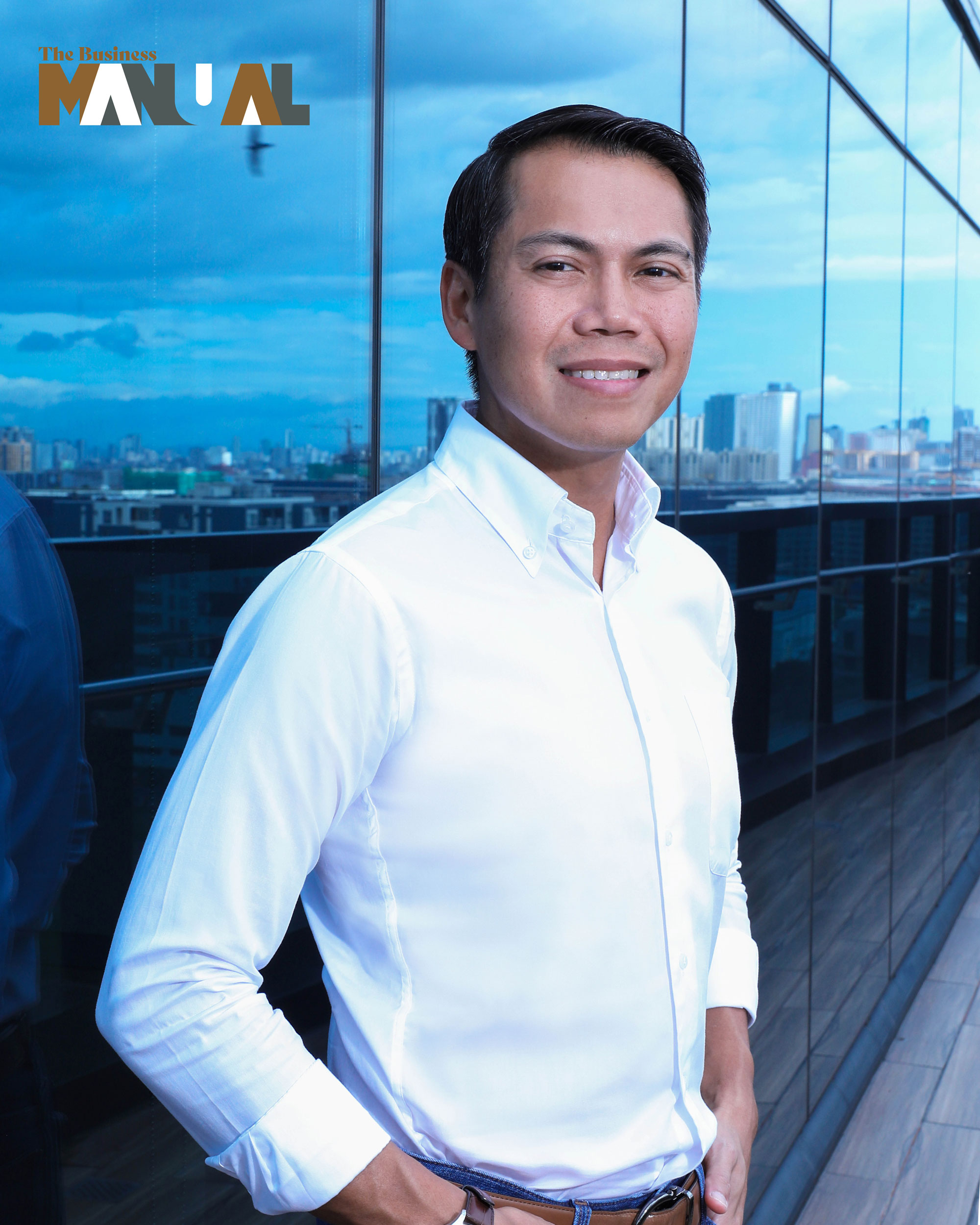 Buds Wenceslao, the CEO of DM Wenceslao and Associates, Inc., standing behind a building